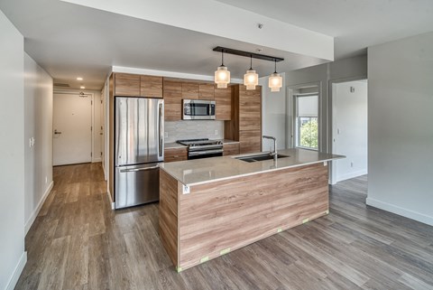A modern kitchen with a wooden island and stainless steel appliances.