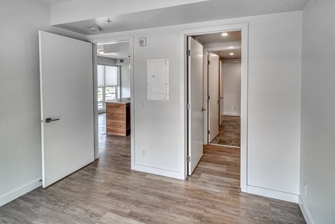 A room with a white door and a white wall with a switchboard.