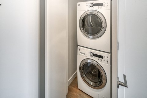 A white dryer and washer are stacked on top of each other.