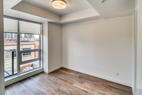 A room with a window overlooking a balcony.