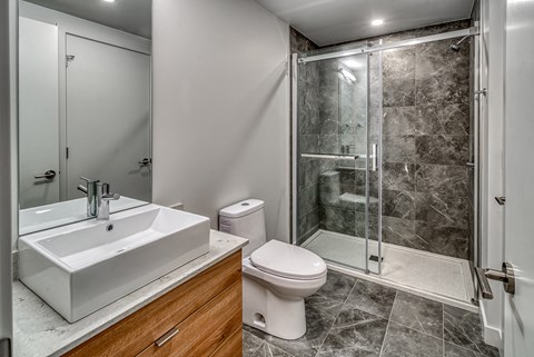 A bathroom with a toilet, sink, and shower.