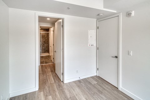 A white door with a white frame is open to a hallway.