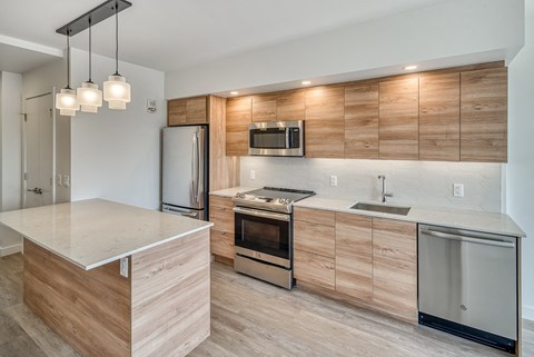 A modern kitchen with wooden cabinets and stainless steel appliances.