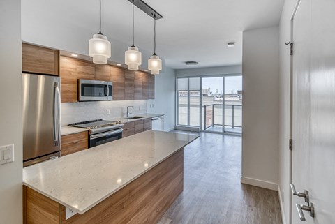 A modern kitchen with a stainless steel refrigerator and wooden accents.
