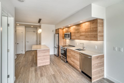 A modern kitchen with wooden cabinets and stainless steel appliances.