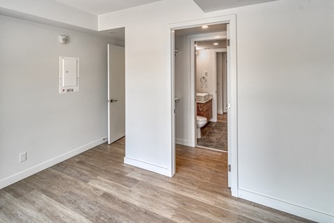 A bathroom with a toilet and sink is visible through an open door.