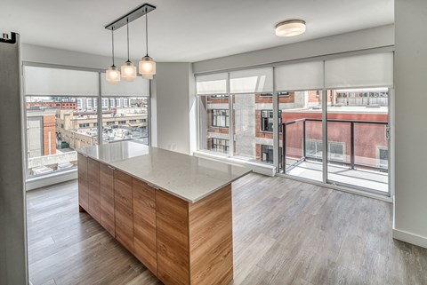 A modern kitchen with a wooden counter and a view of the city.