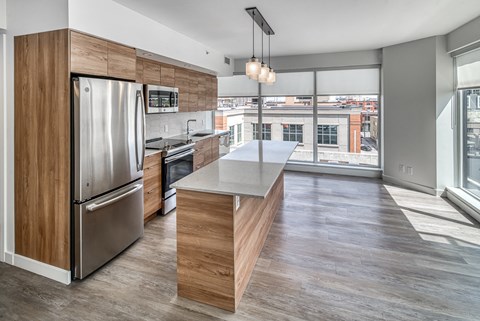 A modern kitchen with a large island and stainless steel appliances.