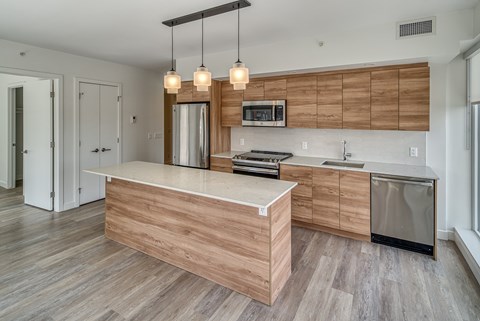 A modern kitchen with wooden cabinets and a central island.