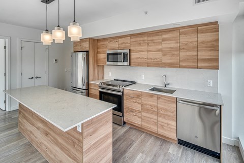 A kitchen with wooden cabinets and a white island.