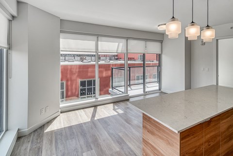 A modern kitchen with a large island and pendant lights.