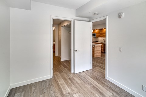 A white door is open to a kitchen.