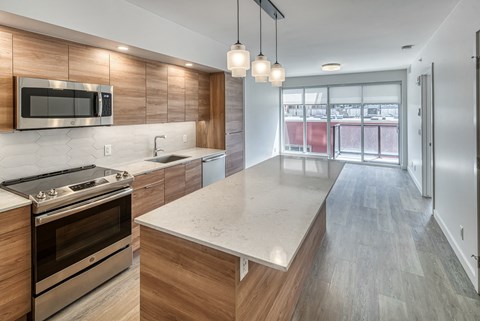 A modern kitchen with a stove top oven and microwave above the counter.