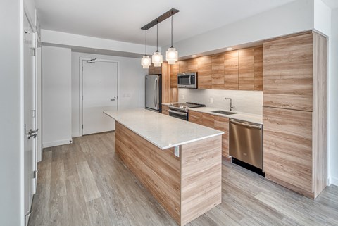 A modern kitchen with wooden cabinets and a white countertop.