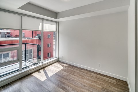 A room with a large window overlooking a red building.