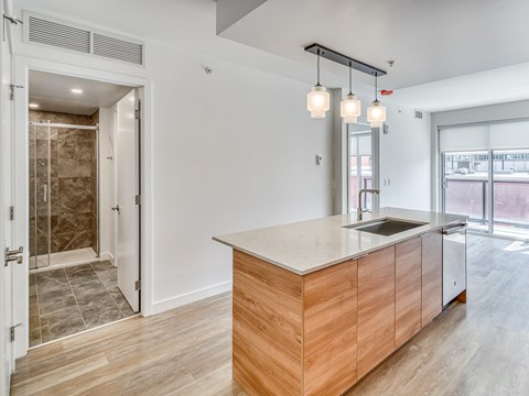 A modern kitchen with a wooden island and pendant lights.