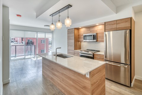 A modern kitchen with a stainless steel refrigerator and wooden accents.