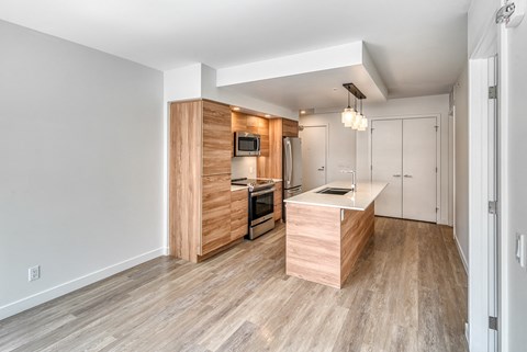 A kitchen with a wooden island and a microwave built into the cabinetry.