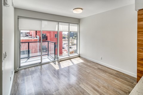 A room with a sliding glass door leading to a balcony.