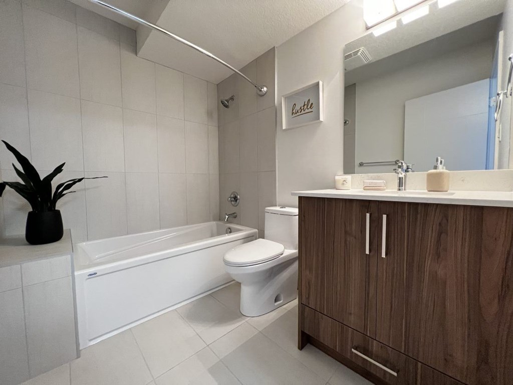 A bathroom with a white tub, toilet, and sink.