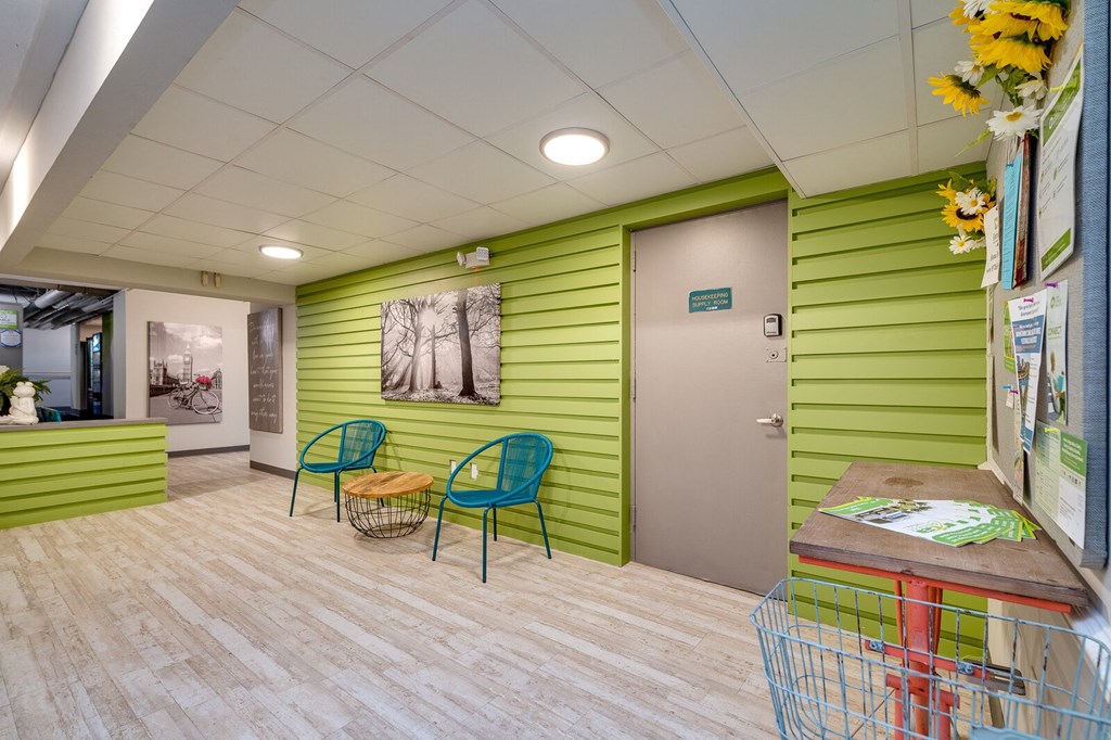 Seating area at Dayton Towers with green walls and a wooden-style floor.