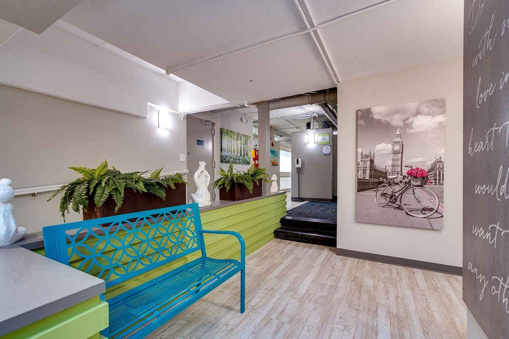 A blue bench with a pattern on it in a room with a chalkboard on the wall at The View at Dayton Towers.