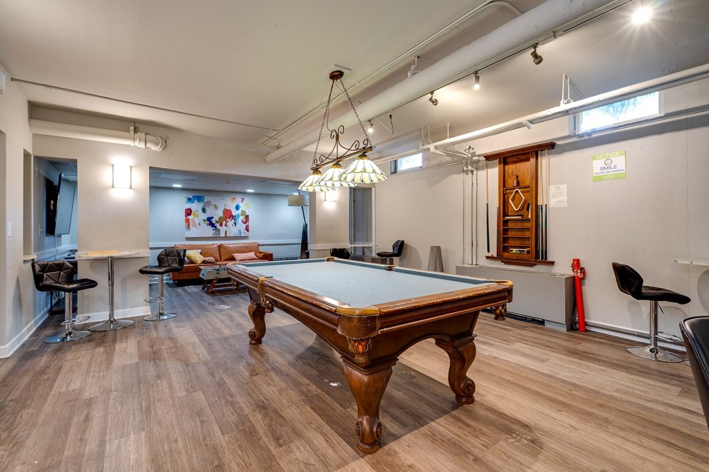 Resident lounge area with a pool table and seating areas at The View at Dayton Towers.