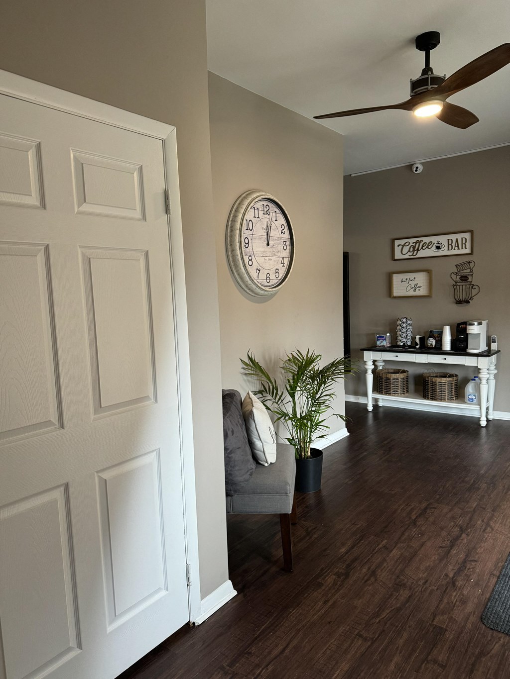 a living room with a chair and a clock on the wall