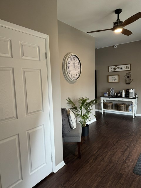 a living room with a chair and a clock on the wall