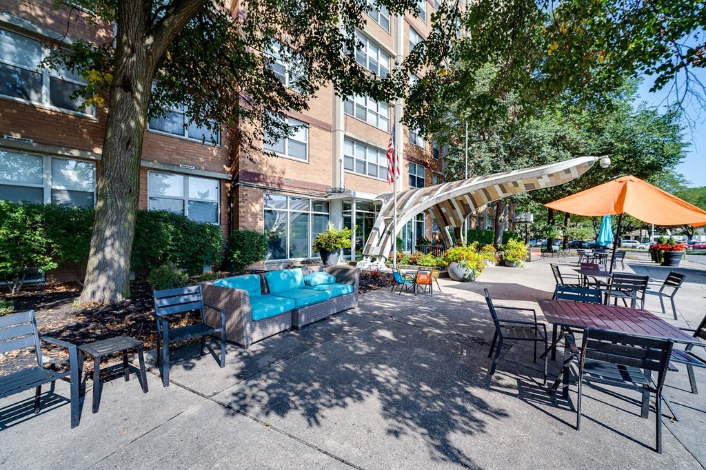 A sunny day at the outdoor seating area of The View at Dayton Towers with tables and chairs.