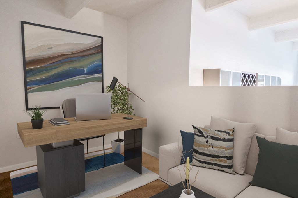 Office area with hardwood-style floors, couch, desk, and area rug at St. Clair Lofts apartments