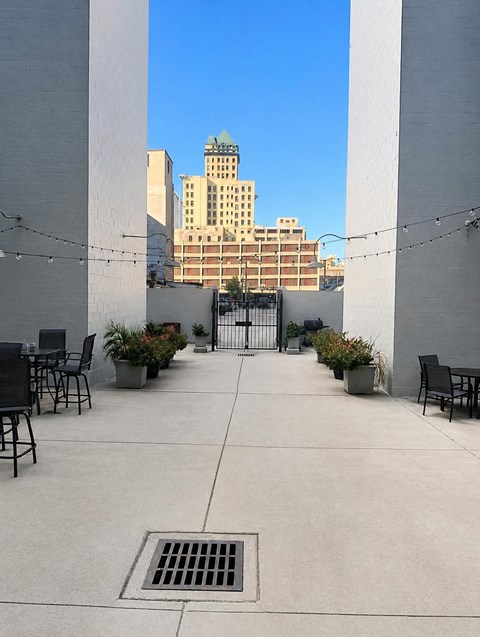 A patio with a table and chairs is surrounded by two tall walls.