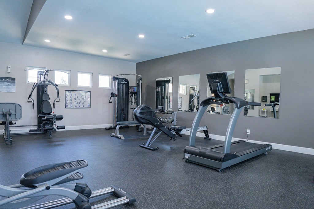 A spacious gym with a variety of equipment including treadmills, weights, and exercise machines.