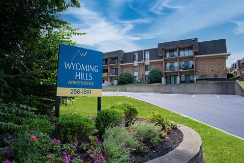 A sign for Wyoming Hills Apartments stands in front of a building.
