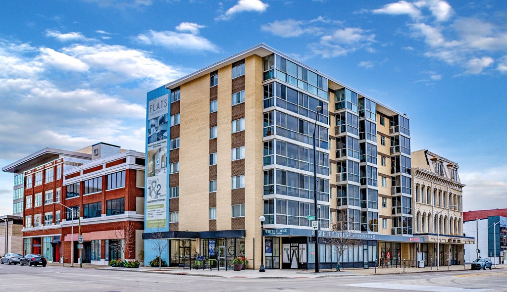 A modern multi-story building with a glass facade is the main focus of the image.