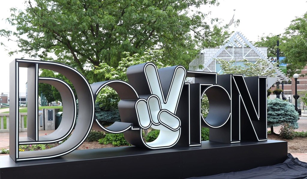 A large outdoor sign with the letters D, O, V, T, N in silver.