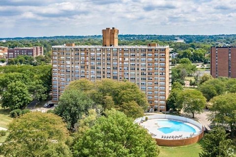 A large building with a pool in front of it.
