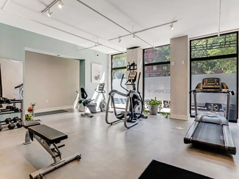 A gym with a variety of equipment including treadmills, weights, and exercise machines.