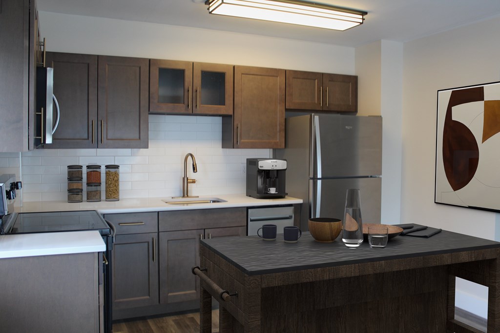 A modern kitchen with dark wood cabinets and stainless steel appliances.