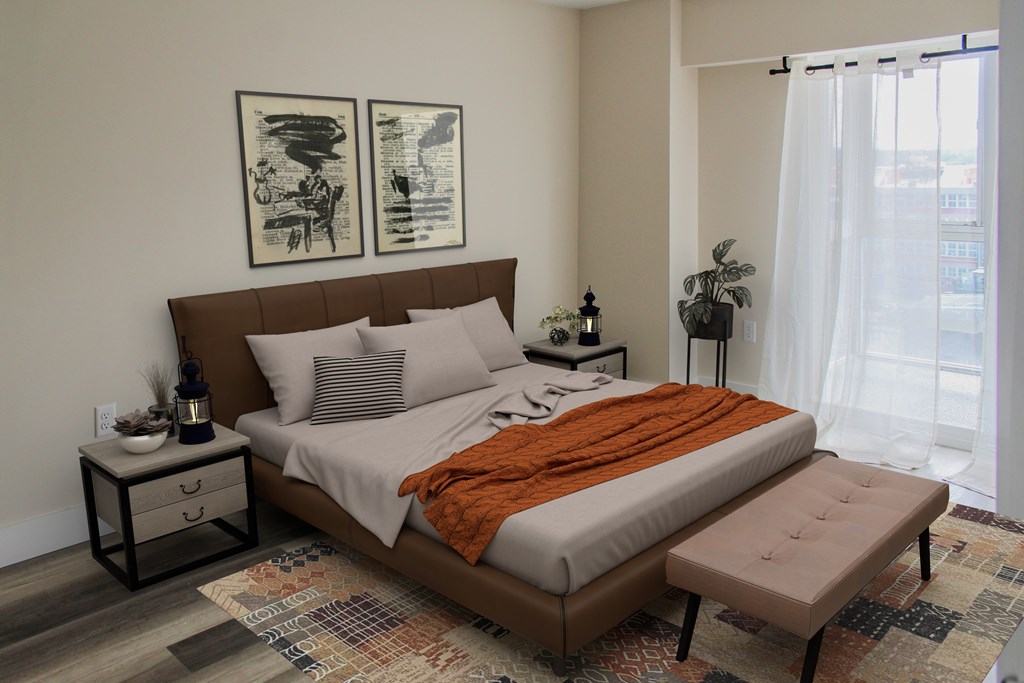 A bedroom with a large bed and two framed pictures on the wall.