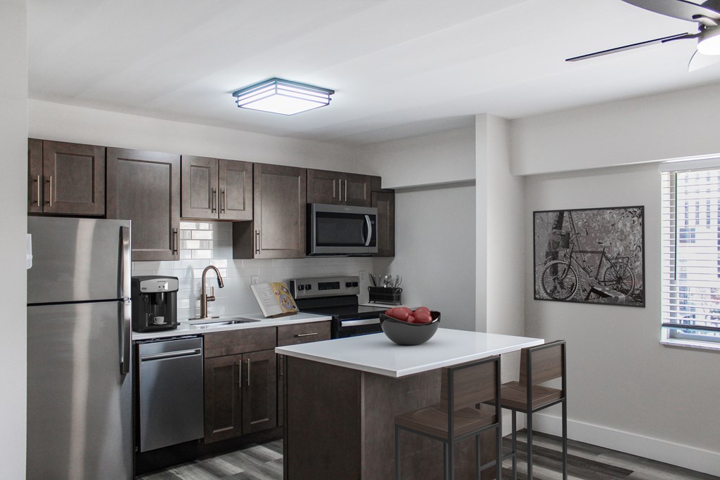 A modern kitchen with stainless steel appliances and wooden cabinets.