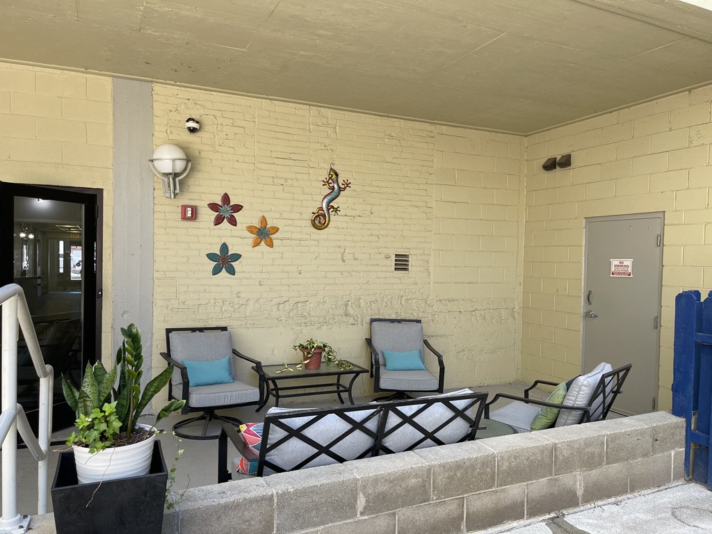 Apartment patio with a table and chairs and a metal decals on the wall at Dayton, OH apartments