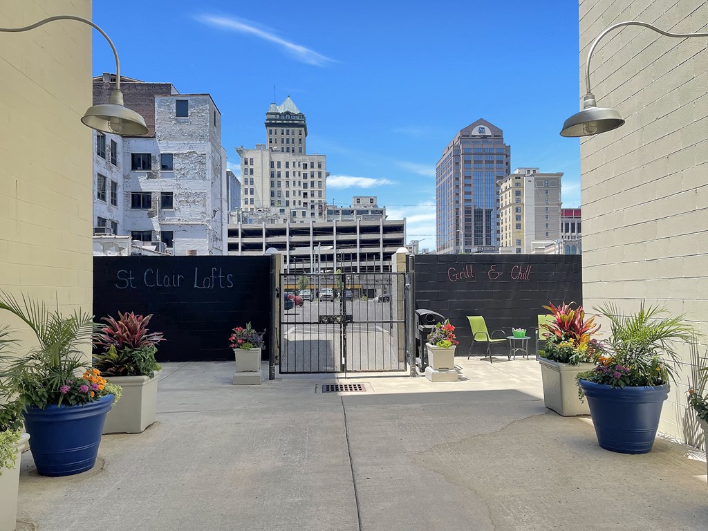 A view of a courtyard with plants, grilling area, and a blackboard that says St. Clair Lofts Grill and Chill