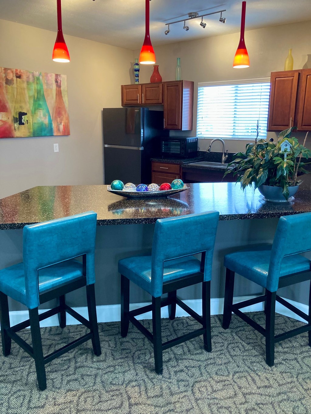 a kitchen with an island with blue chairs