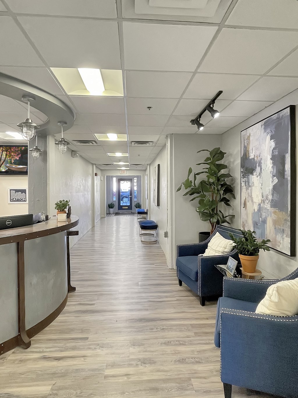 St. Clair Lofts leasing office hallway with blue chairs and a reception desk.