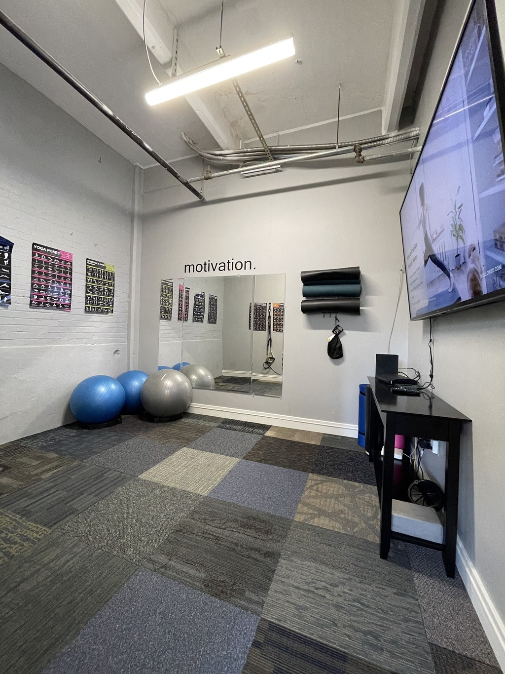 A room with a large screen on the wall and a bunch of exercise balls on the floor at Dayton, OH apartments