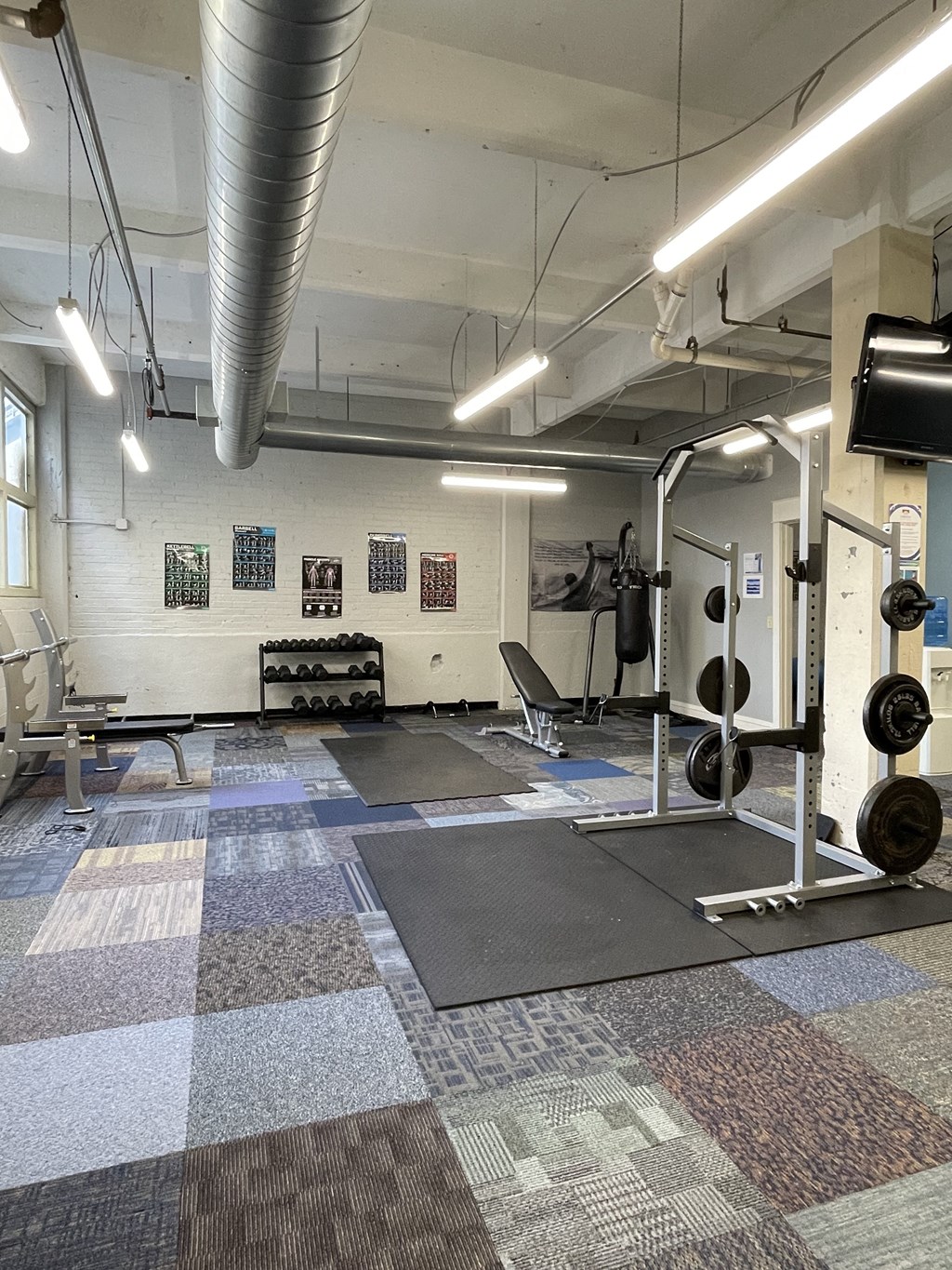 A view of the fitness center at St. Clair Lofts with weights machines and other exercise equipment