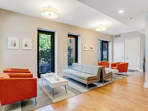 A living room with a white couch and orange chairs.