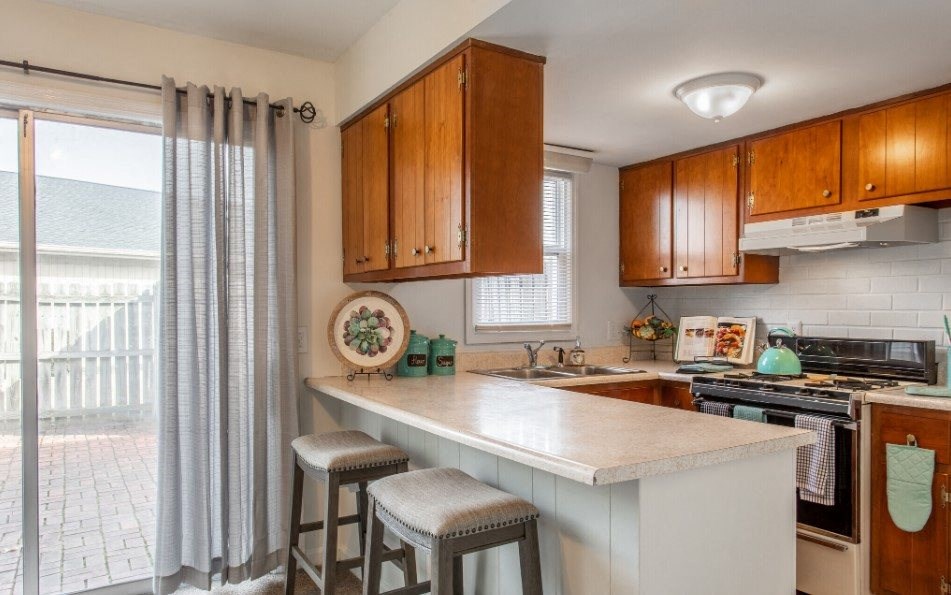 Model unit kitchen with an island and two stools.