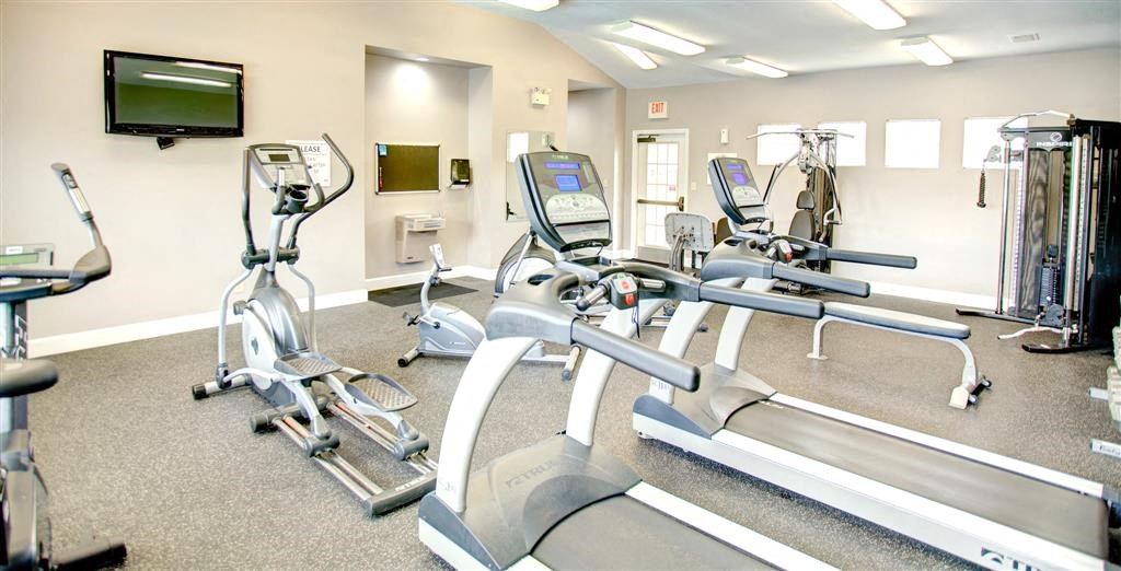 a gym with cardio equipment and a television